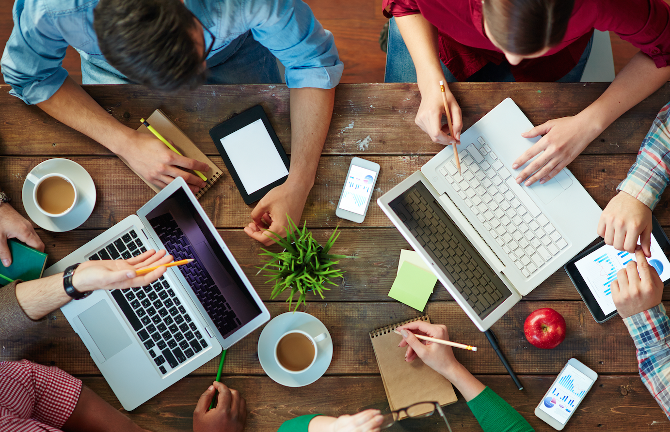 People meeting with laptops and discussing email marketing stats